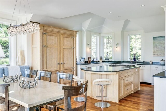 31 Moss Rd, Yarmouth, MA 02673 - kitchen featuring dark countertops, wood finished floors, a wealth of natural light, and a kitchen island