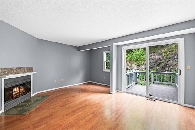 13 Fillmore Rd Unit 15Ab, Salem, MA 01970 - unfurnished living room featuring wood finished floors, a textured ceiling, and a tile fireplace