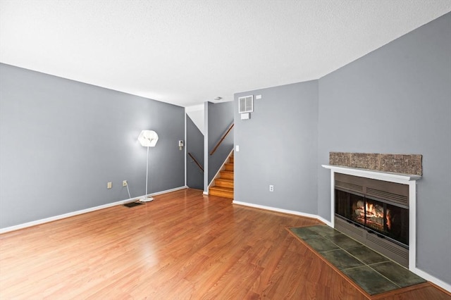 13 Fillmore Rd Unit 15Ab, Salem, MA 01970 - unfurnished living room featuring stairway, a fireplace with flush hearth, and wood finished floors