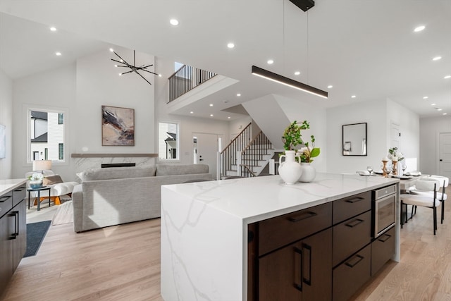 kitchen featuring light hardwood / wood-style floors, a kitchen island, light stone countertops, and stainless steel microwave