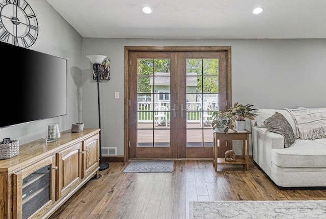 doorway with french doors, recessed lighting, wood finished floors, and visible vents