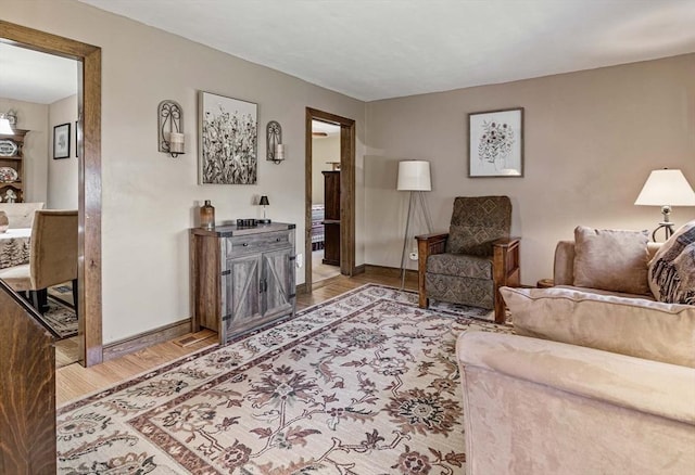 living area featuring light wood-style floors and baseboards