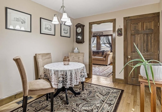 dining room featuring light wood-style floors and a notable chandelier