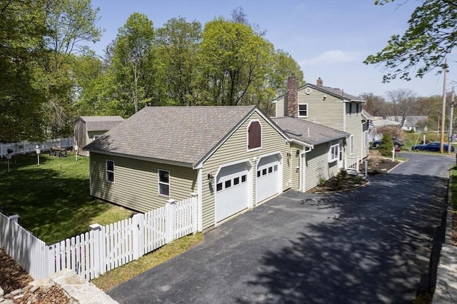 view of property exterior with a garage, aphalt driveway, fence, a chimney, and a shingled roof