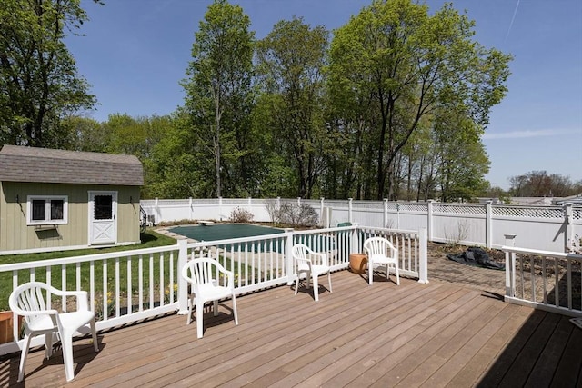 deck with a fenced backyard, an outbuilding, and a yard
