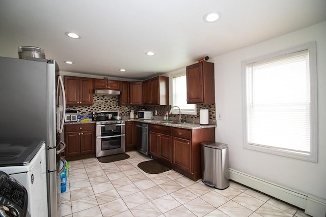 33 Cady St, Lowell, MA 01852 - kitchen with appliances with stainless steel finishes, baseboard heating, decorative backsplash, light stone countertops, and a sink