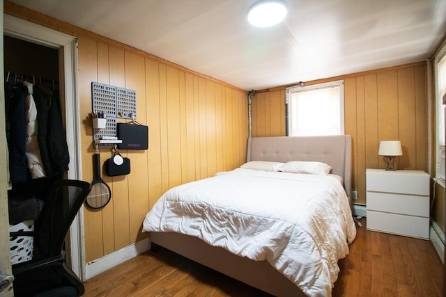 33 Cady St, Lowell, MA 01852 - bedroom with wood finished floors, wood walls, multiple windows, baseboards, and baseboard heating