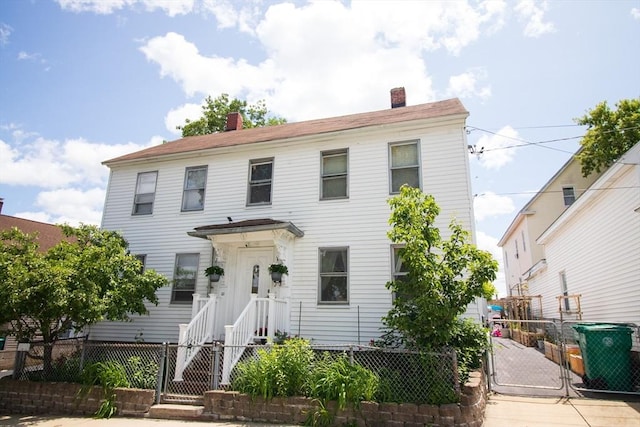 33 Cady St, Lowell, MA 01852 - view of front facade with a gate, a fenced front yard, and a chimney