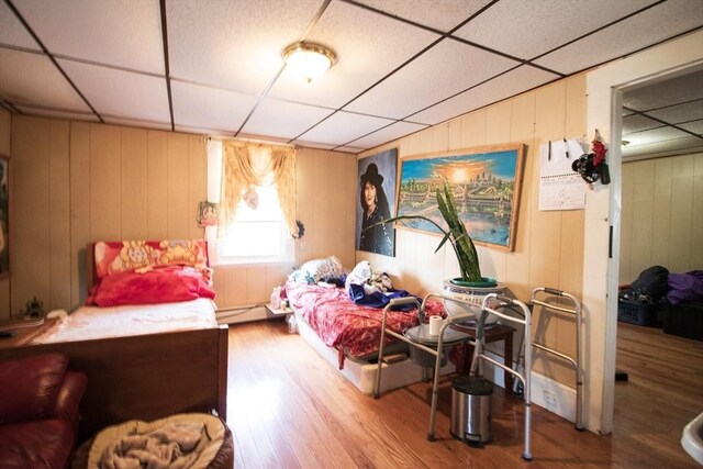 33 Cady St, Lowell, MA 01852 - bedroom with a drop ceiling, baseboard heating, wood finished floors, and wood walls