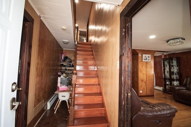 33 Cady St, Lowell, MA 01852 - staircase with a baseboard heating unit, wood walls, and wood finished floors