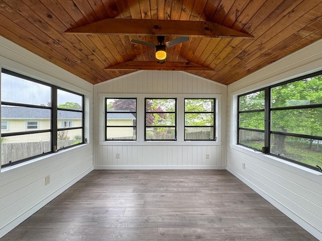 unfurnished sunroom featuring wood finished floors, ceiling fan, healthy amount of natural light, wooden walls, and wood ceiling