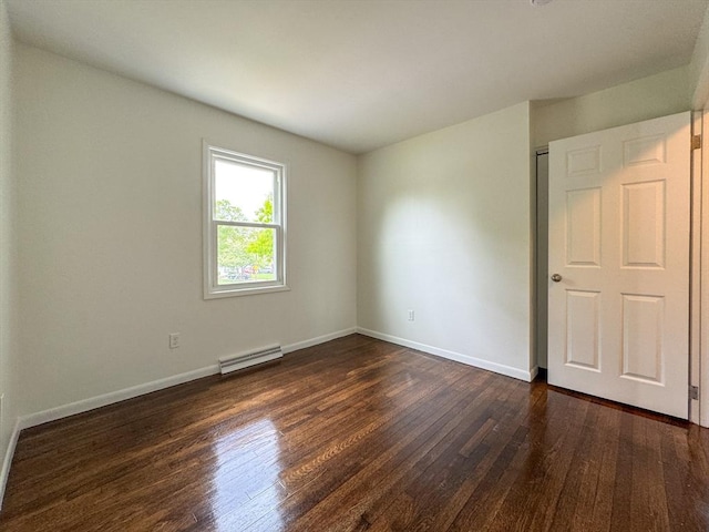 empty room featuring dark wood finished floors and baseboards