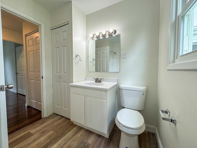 bathroom featuring wood finished floors, toilet, baseboards, and vanity