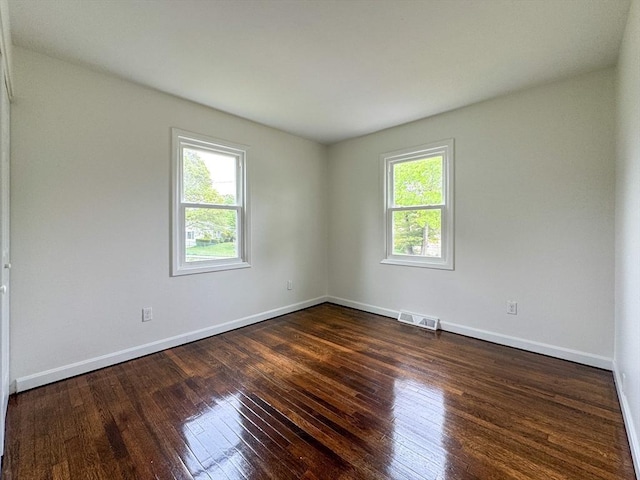 spare room with dark wood-style floors and baseboards