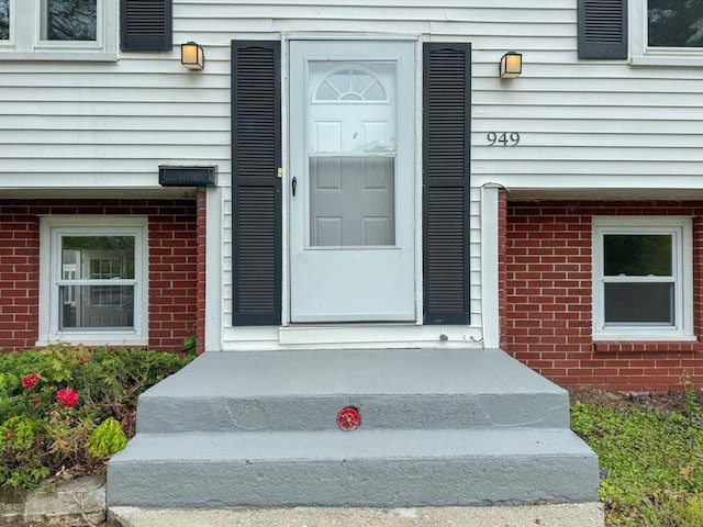 entrance to property featuring brick siding
