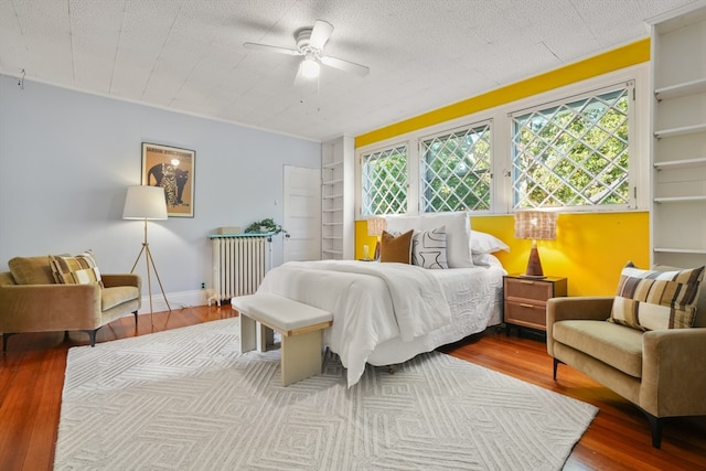 bedroom featuring ceiling fan, light hardwood / wood-style flooring, a textured ceiling, and radiator