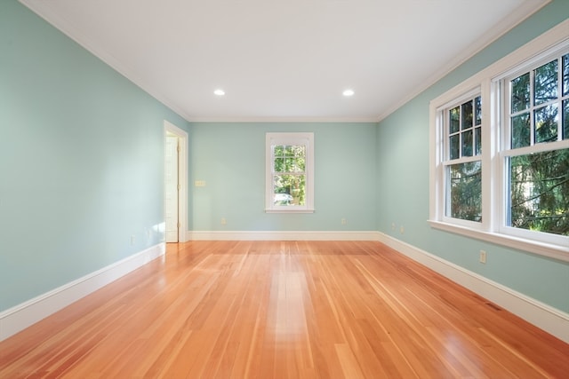 empty room with crown molding and light hardwood / wood-style flooring