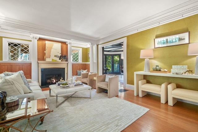 interior space with ornate columns, wood-type flooring, and ornamental molding