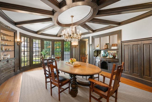 dining space featuring crown molding, beam ceiling, an inviting chandelier, and light wood-type flooring