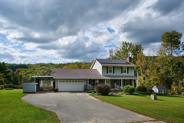 view of front of property featuring a garage, a front yard, solar panels, and covered porch