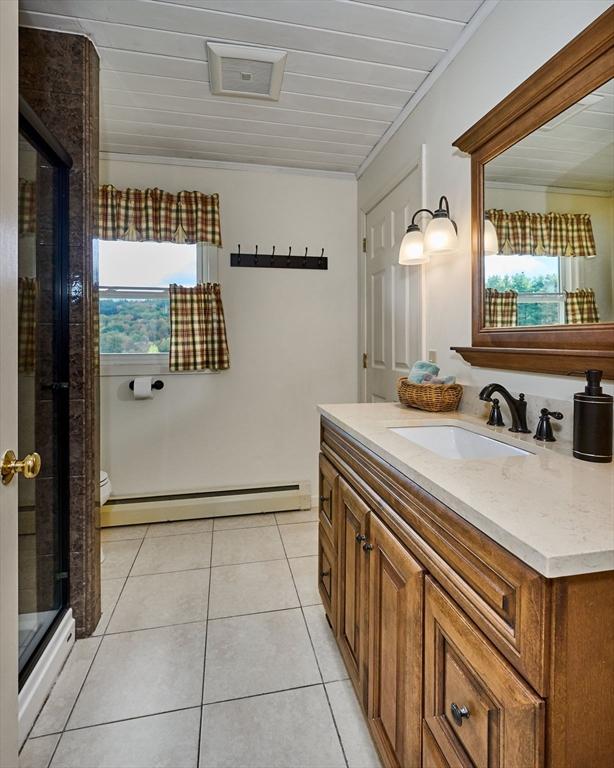 10 Phillips Dr, Colrain, MA 01340 - bathroom with baseboard heating, vanity, a stall shower, toilet, and tile patterned flooring