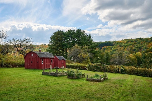 10 Phillips Dr, Colrain, MA 01340 - view of grassy yard with a vegetable garden, an outdoor structure, a barn, and a view of trees