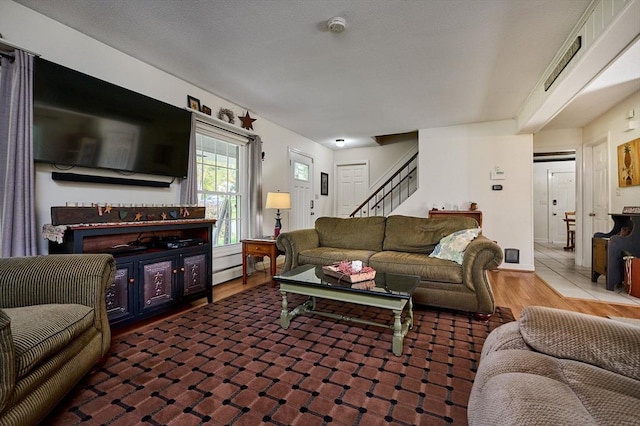 10 Phillips Dr, Colrain, MA 01340 - living room featuring stairs, wood finished floors, and a baseboard heating unit