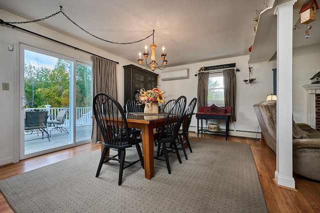10 Phillips Dr, Colrain, MA 01340 - dining space featuring a wall mounted AC, a chandelier, plenty of natural light, and light wood-style floors