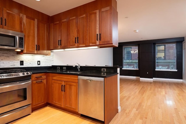 kitchen with brown cabinetry, stainless steel appliances, and a sink