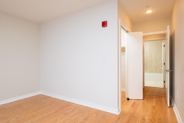 hall featuring light wood-style floors and baseboards