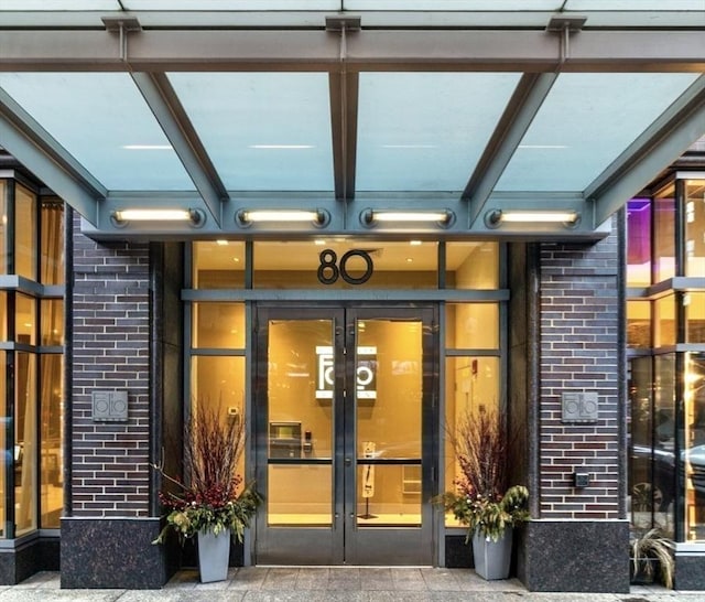 view of exterior entry with french doors and brick siding