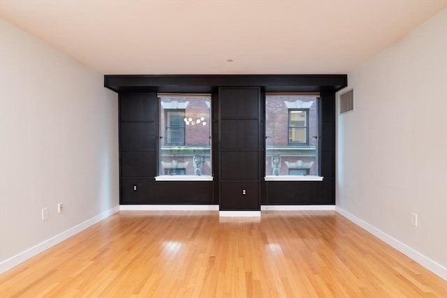 empty room featuring wood finished floors and baseboards