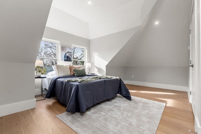 bedroom featuring light hardwood / wood-style floors and lofted ceiling