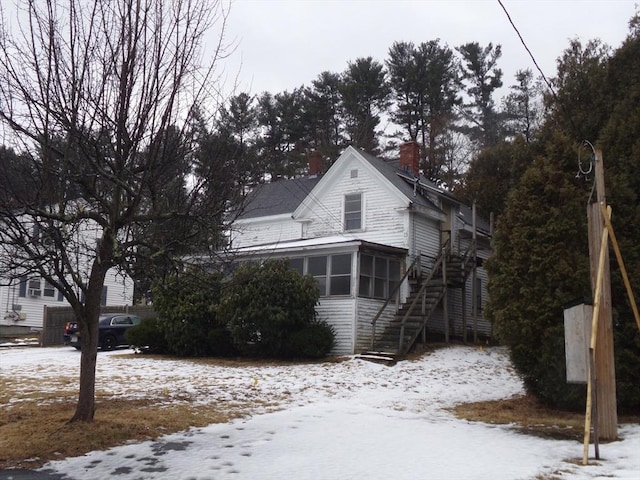 view of snow covered exterior with a sunroom