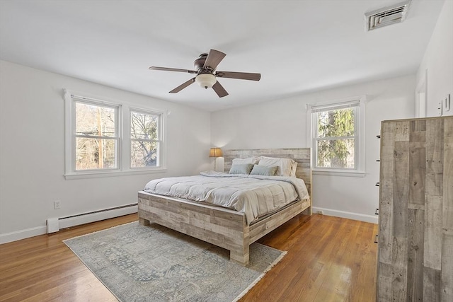 bedroom featuring a baseboard radiator, light wood-type flooring, and ceiling fan