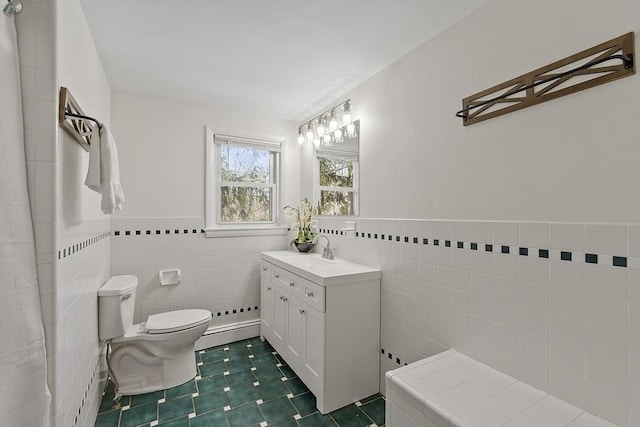 bathroom featuring tile patterned floors, toilet, tile walls, a baseboard radiator, and vanity