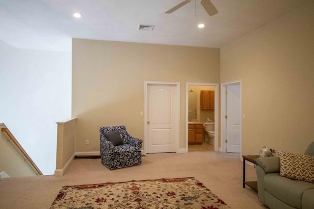 living area with recessed lighting, baseboards, light colored carpet, and an upstairs landing