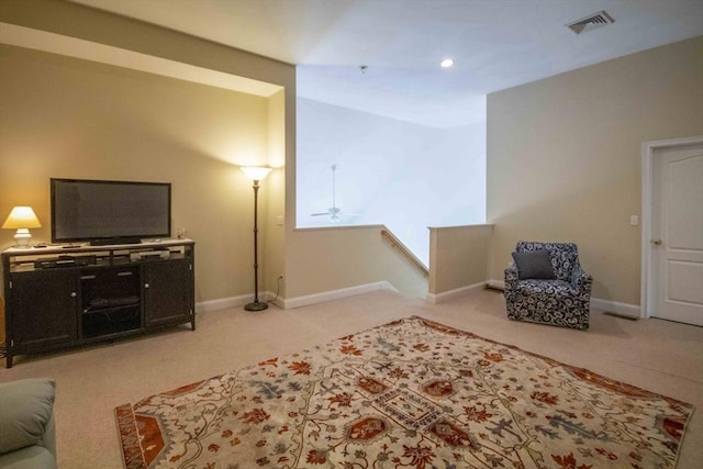 living area featuring ceiling fan, carpet, visible vents, and baseboards