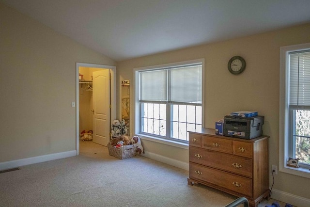 bedroom featuring baseboards, visible vents, vaulted ceiling, and light colored carpet