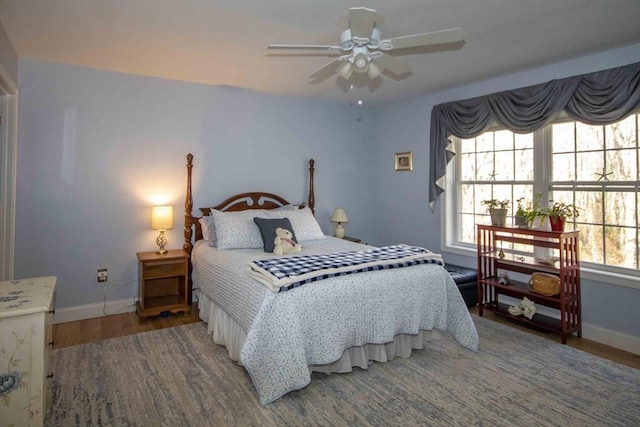 bedroom featuring ceiling fan, baseboards, and wood finished floors