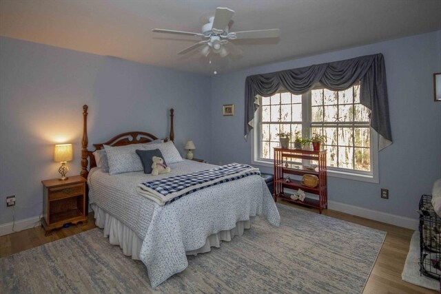 bedroom with ceiling fan, baseboards, and wood finished floors