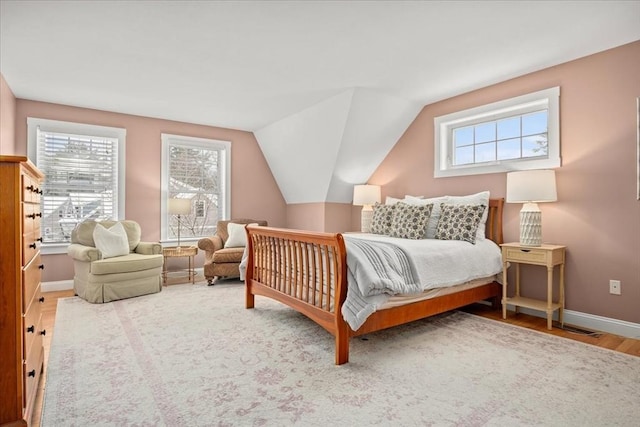 bedroom featuring baseboards, vaulted ceiling, and wood finished floors