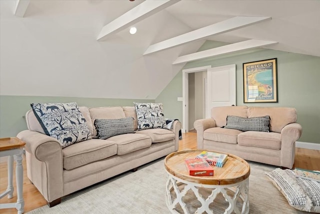 living area with vaulted ceiling, baseboards, and wood finished floors