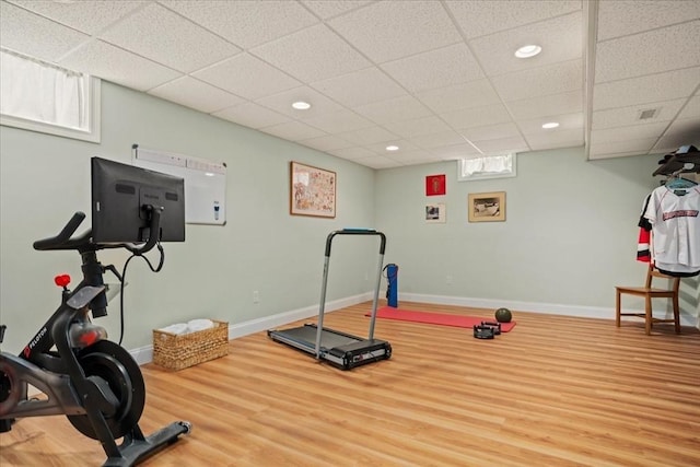 exercise room featuring baseboards, wood finished floors, and recessed lighting