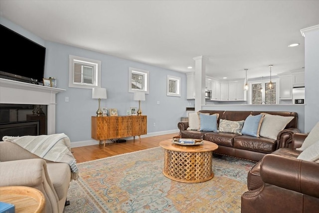 living area featuring baseboards, wood finished floors, and recessed lighting