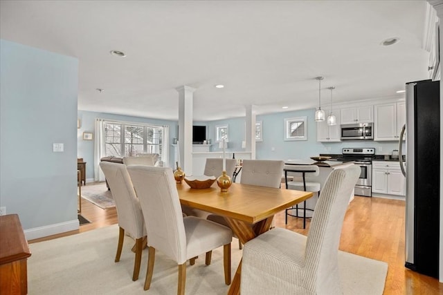 dining area with light wood-type flooring, decorative columns, baseboards, and recessed lighting