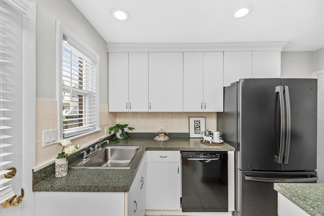 kitchen with sink, white cabinets, dishwasher, and stainless steel refrigerator