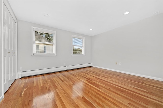 unfurnished room with light hardwood / wood-style floors and baseboard heating