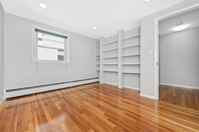 interior space with light hardwood / wood-style flooring, built in features, and a baseboard radiator