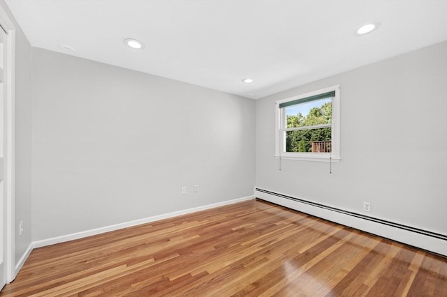 empty room featuring light hardwood / wood-style floors and a baseboard radiator